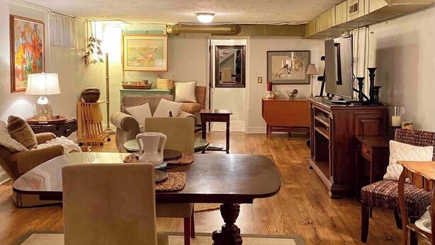 Una sala de estar acogedora con una mesa de comedor, sillas y una zona de cocina al fondo.