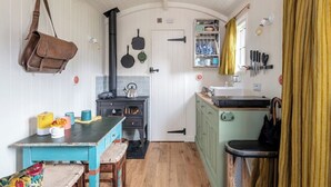 A compact kitchen with a stove, a sink, and a small cabinet. - Beautiful hut in countryside garden with wood fired hot tub near Bath & Frome (Wingfield)
