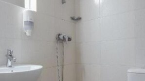 A bathroom with a white sink, a mirror, and a shower. - Sara (Neptun)
