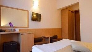 A hotel room with a bed, a desk, a television, and a wardrobe. - Sara (Neptun)