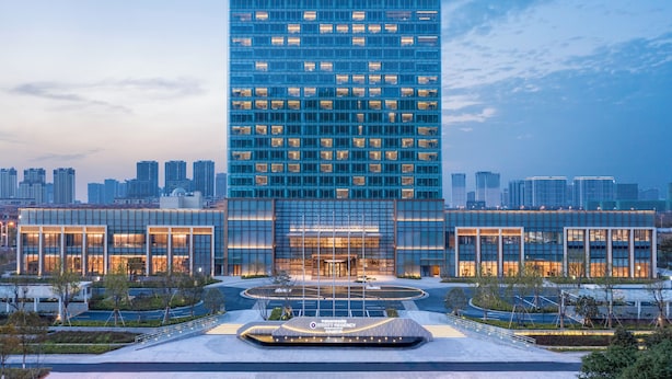 Een modern Hyatt Regency hotel met een glazen gevel, een centrale ingang en een aangelegde binnentuin.