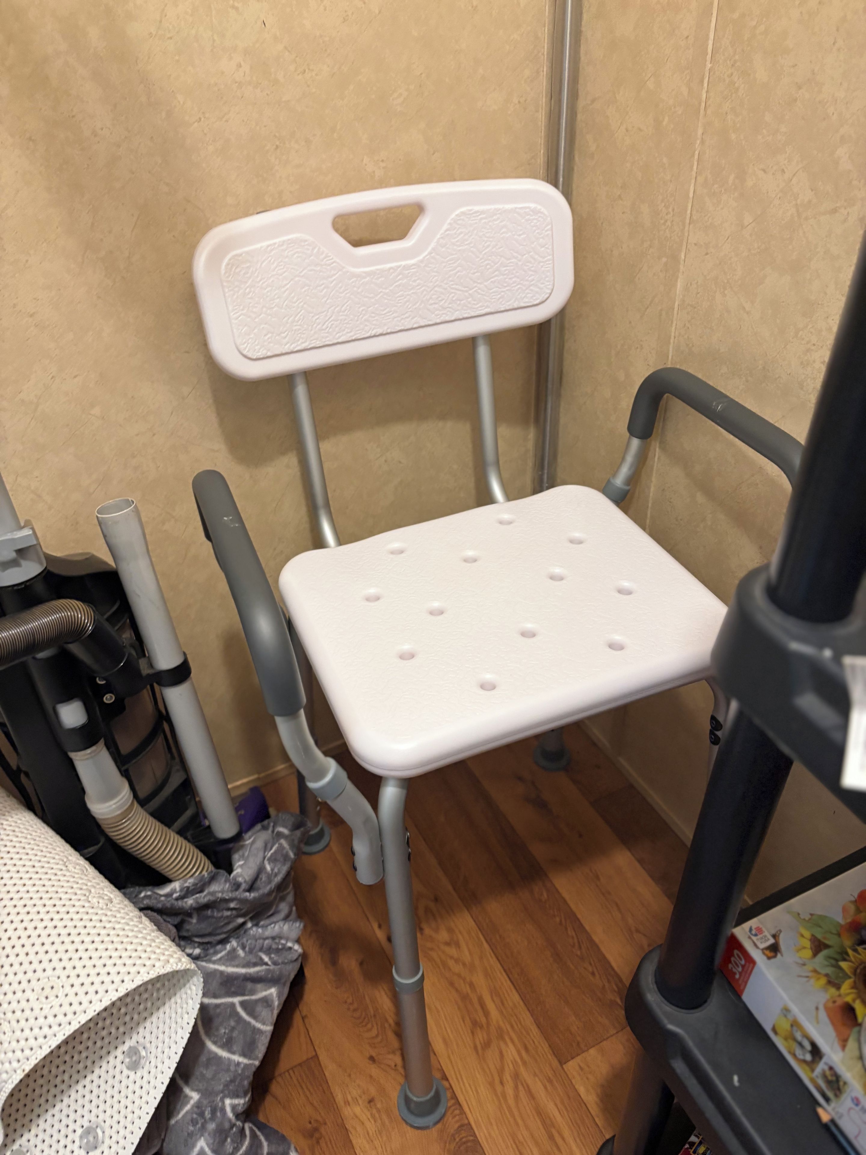 Quarto com uma cadeira branca, esteira e equipamentos de ginástica.