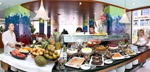 A buffet with various food items and a tropical fruit display. - Magic INN (Oropesa del Mar)