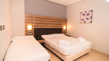 Una habitación de hotel con dos camas, cabecero de madera, lámparas de noche y un cuadro colgado en la pared.