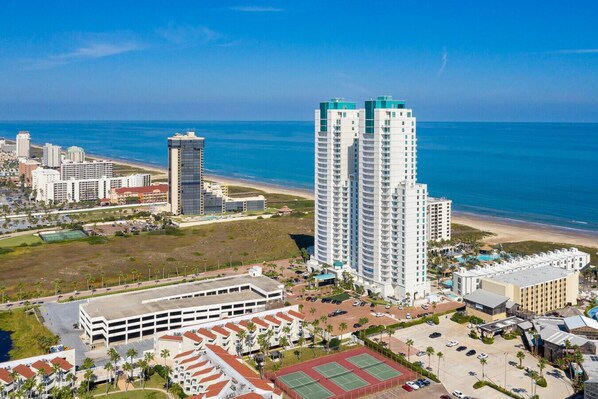 Un hotel de gran altura con varios pisos, un estacionamiento y vistas a la playa.