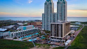 Un hotel di grandi dimensioni con numerosi balconi, una zona piscina e vista sull'oceano.