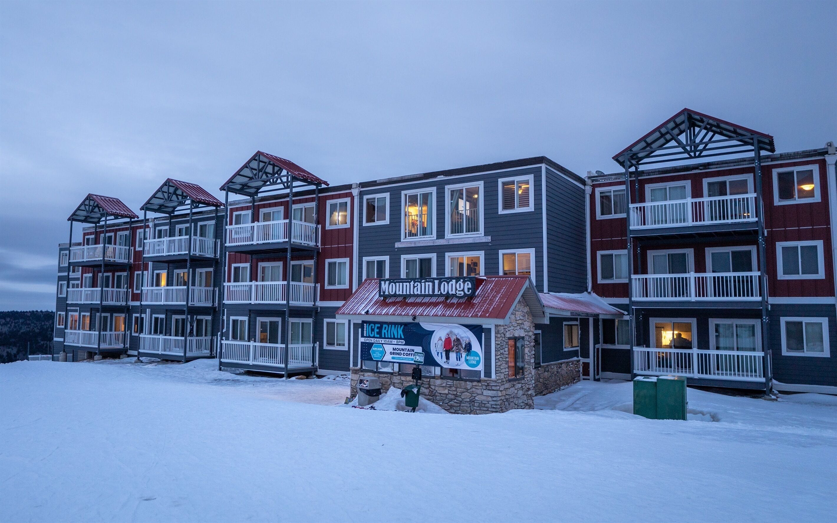Un hotel a più piani con balconi e un cartello con scritto Mountain Lodge.