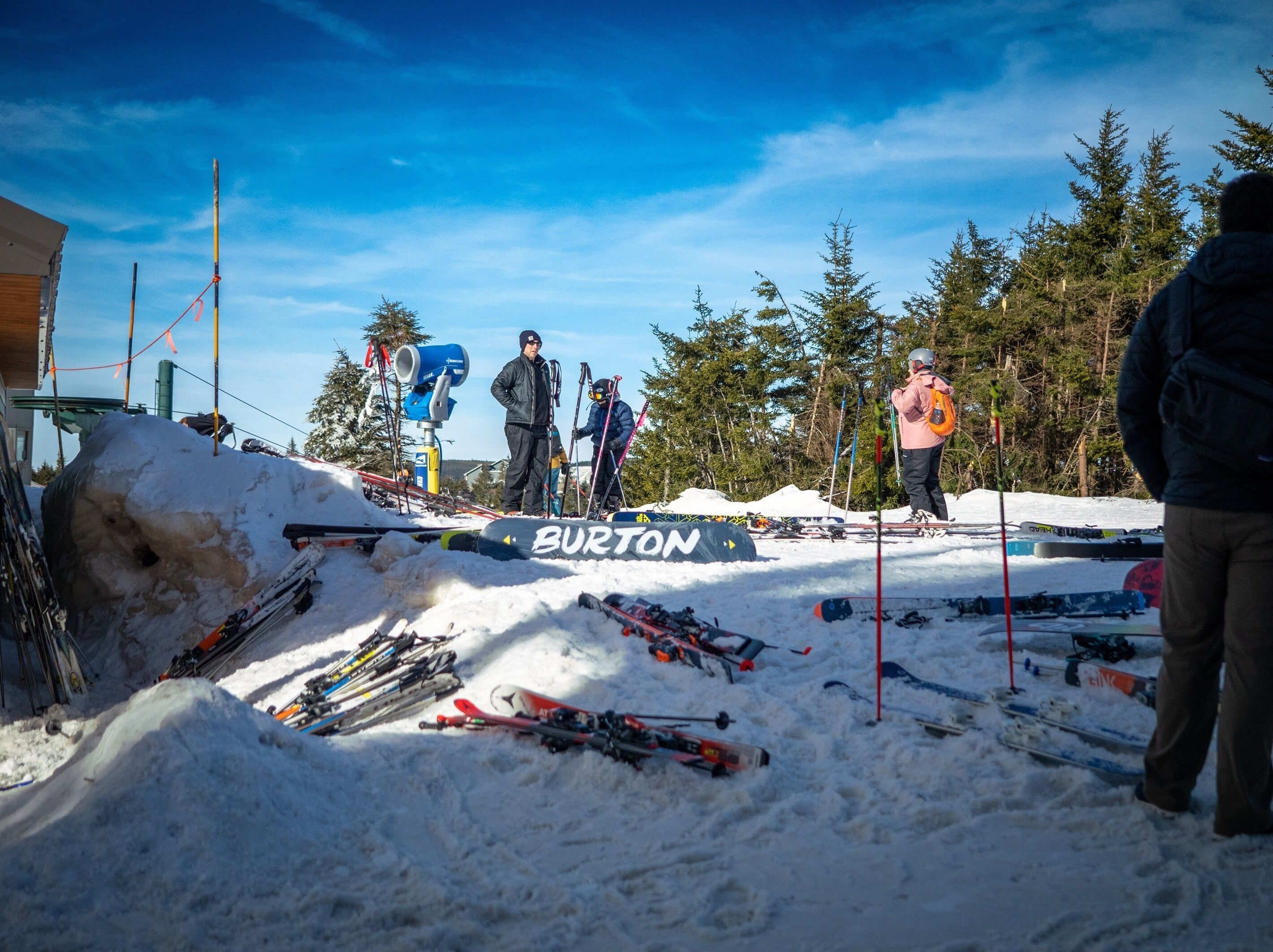 A ski slope with a Burton logo, surrounded by snow and trees.