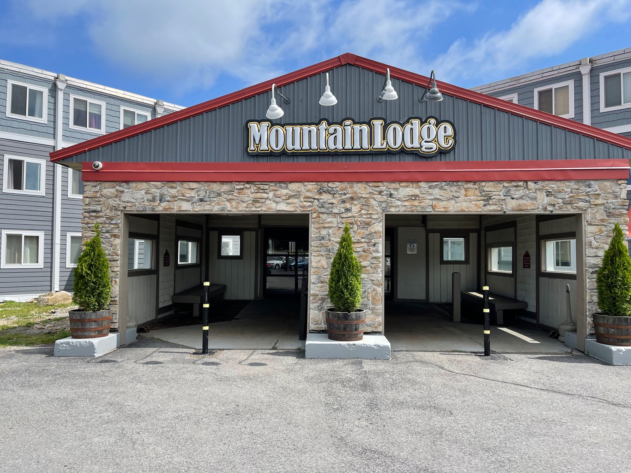 Un bâtiment de style chalet de montagne, avec une façade en pierre et deux entrées.