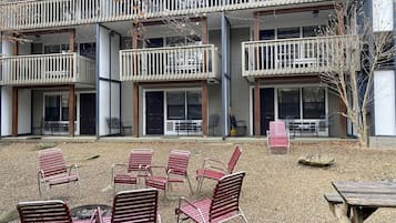A multi-story building with outdoor seating and a covered patio area.