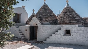 Un edificio tradicional con tejado de piedra y una escalera que lleva a una puerta.