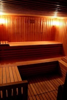 A sauna with wooden benches and a sloped floor.
