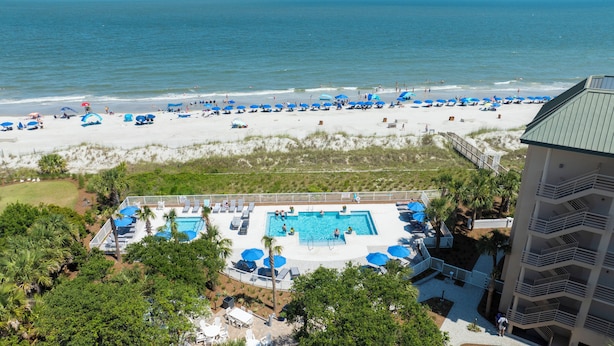 A resort with a pool area, beach access, and a building with balconies. - Comfortable Two Bedroom Villamare Condominium in Palmetto Dunes! (Hilton Head)