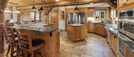 Una cocina amplia con armarios de madera, una isla central y electrodomésticos de acero inoxidable.