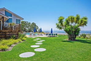 Une maison moderne dotée d’une piscine, d’un espace extérieur aménagé et offrant une vue dégagée sur le paysage.