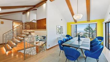 A modern interior with a dining area, staircase, and kitchen.
