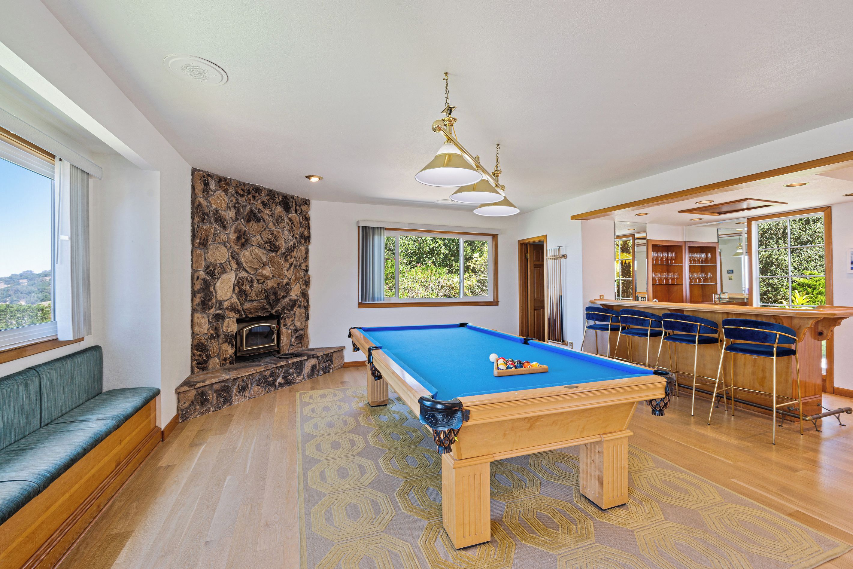A pool table with a bar area and seating.