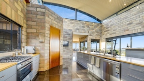 Una cocina moderna con pared de piedra, puerta de madera y vistas a la ciudad.
