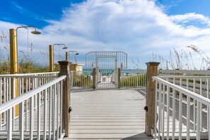 Walk along the boardwalk to the entrance, flanked by railings and lamp posts.
