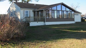 A single-story house with a large bay window and a covered porch. - Little Bay Waterfront Retreat (White Stone)