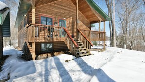 Eine Holzhütte mit einer Veranda und einer Treppe, die zum Eingang führt.