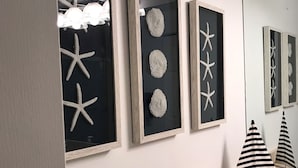 A bathroom with a wooden vanity, a mirror, and three framed artworks on the wall. - Resort living (Lantana)
