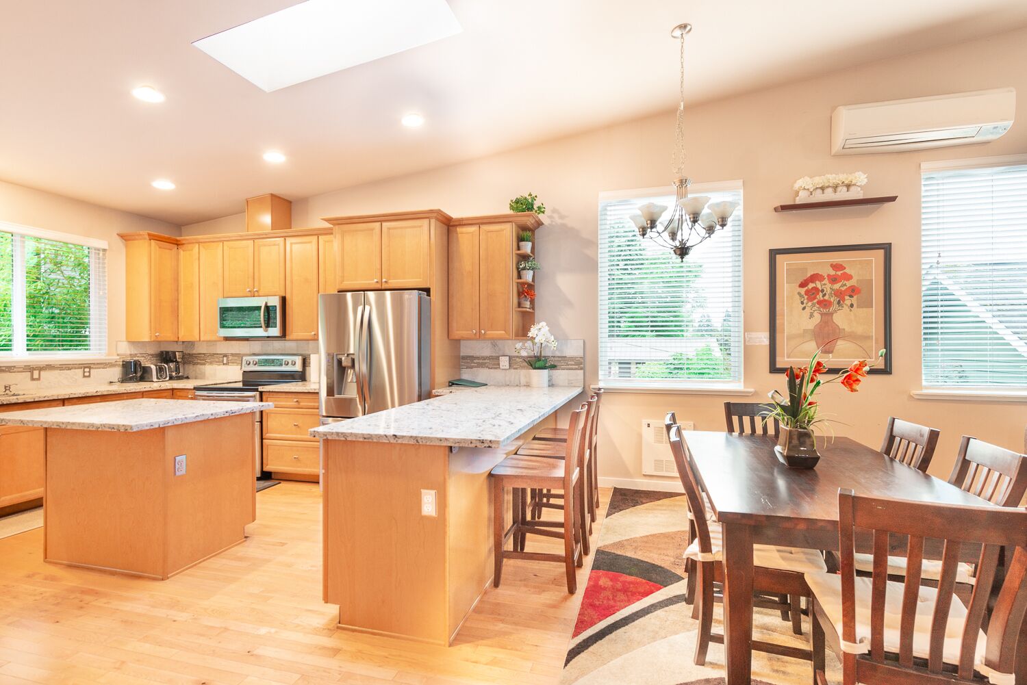 A modern kitchen with wooden cabinets, stainless steel appliances, and a large island with seating.