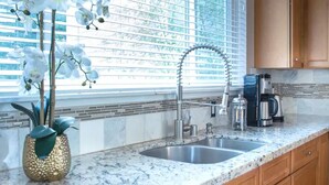 A kitchen with a granite countertop, stainless steel sink, and wooden cabinets. - Spacious Seattle Duplex Home for Families and Pets! (Seattle)