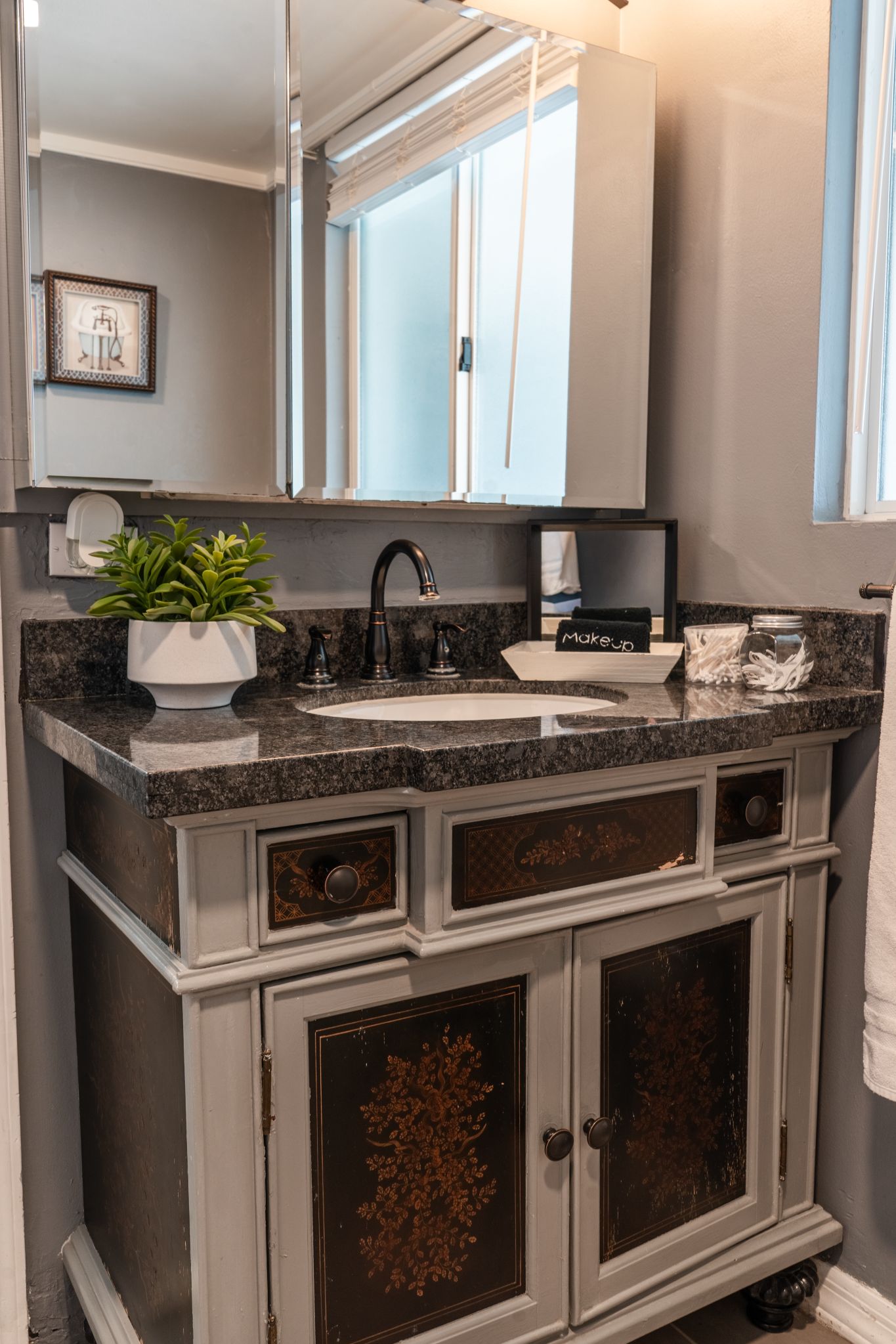 A bathroom vanity with a sink, mirror, and cabinet.