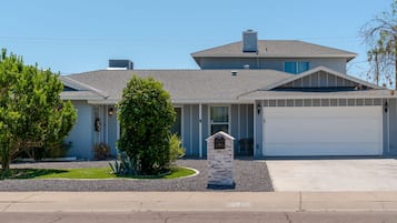 A two-story house with a garage, a stone mailbox, and a well-maintained lawn.