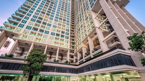 A high-rise hotel with multiple floors, balconies, and a central courtyard with seating areas.