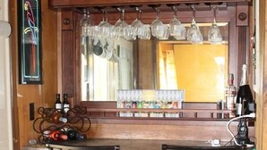 A bar area with two metal barstools, a wooden counter, and a neon sign reading "Cocktails". - 3bd/2ba Summit Condo Close to Village and on shuttle route.  (Snowshoe)