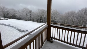 A covered balcony with a view of a snow-covered landscape and trees. - 3bd/2ba Summit Condo Close to Village and on shuttle route.  (Snowshoe)