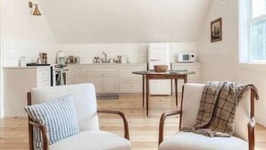 A cozy kitchen with white cabinets, a dining table, and two chairs.
