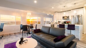 A modern apartment with a living room, dining area, and kitchen.