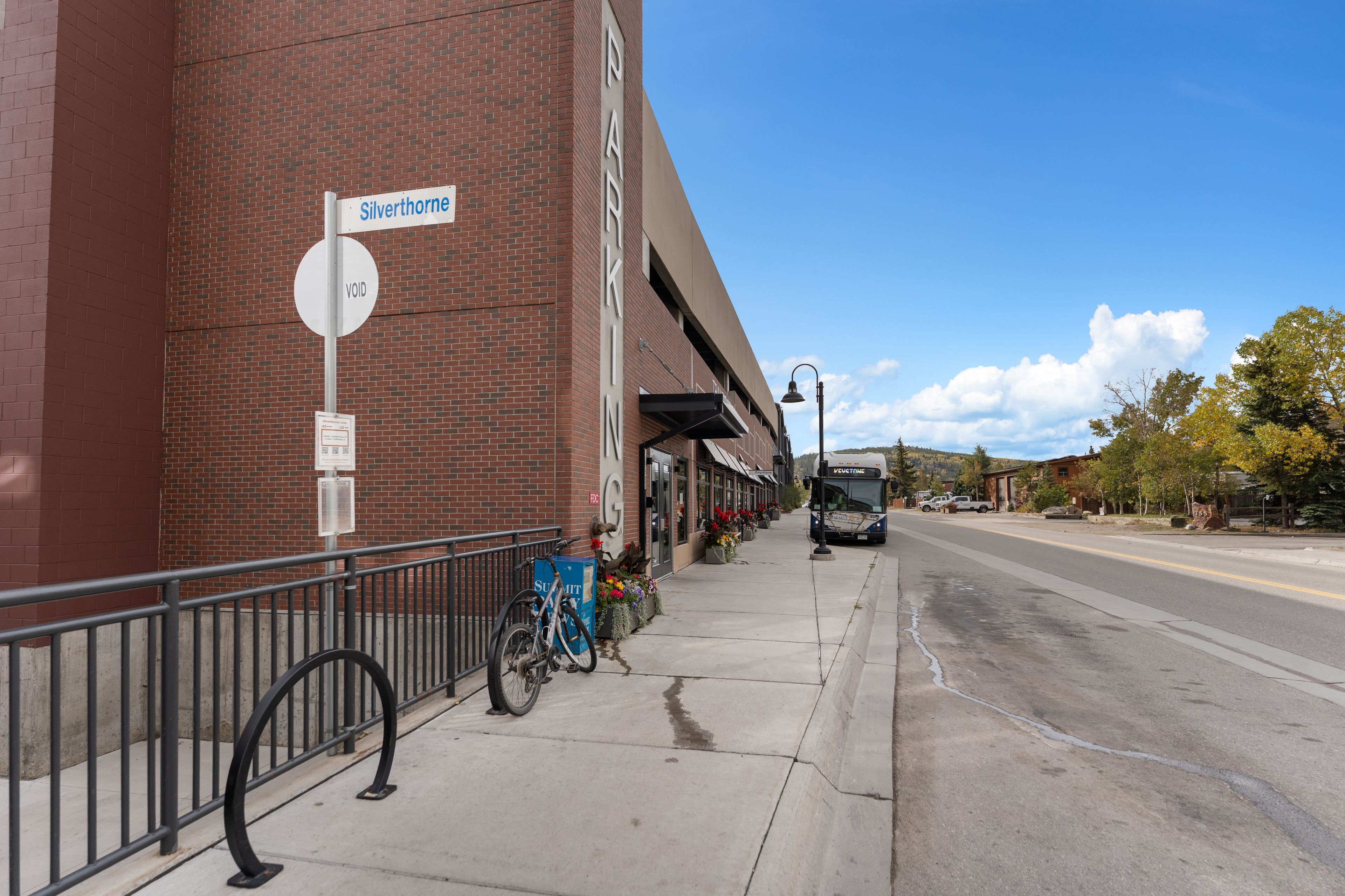 A street view with a brick building, a 'VOID' sign, a bicycle, and a bus.