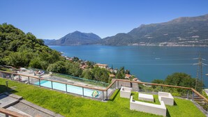 Zwembad met uitzicht op een meer en bergen.