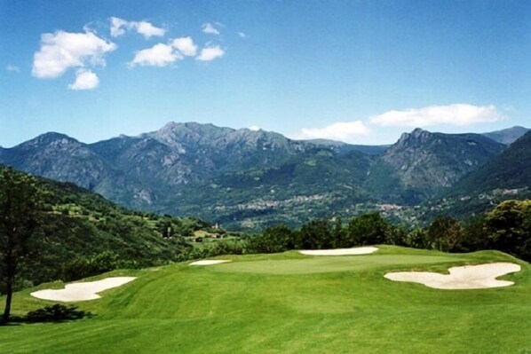 A golf course with a clear view of mountains in the background.