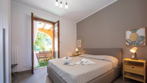 A bedroom with a bed, bedside lamps, a nightstand, a door leading to an outdoor area, and a painting on the wall. - Menaggio Palphi (Menaggio)
