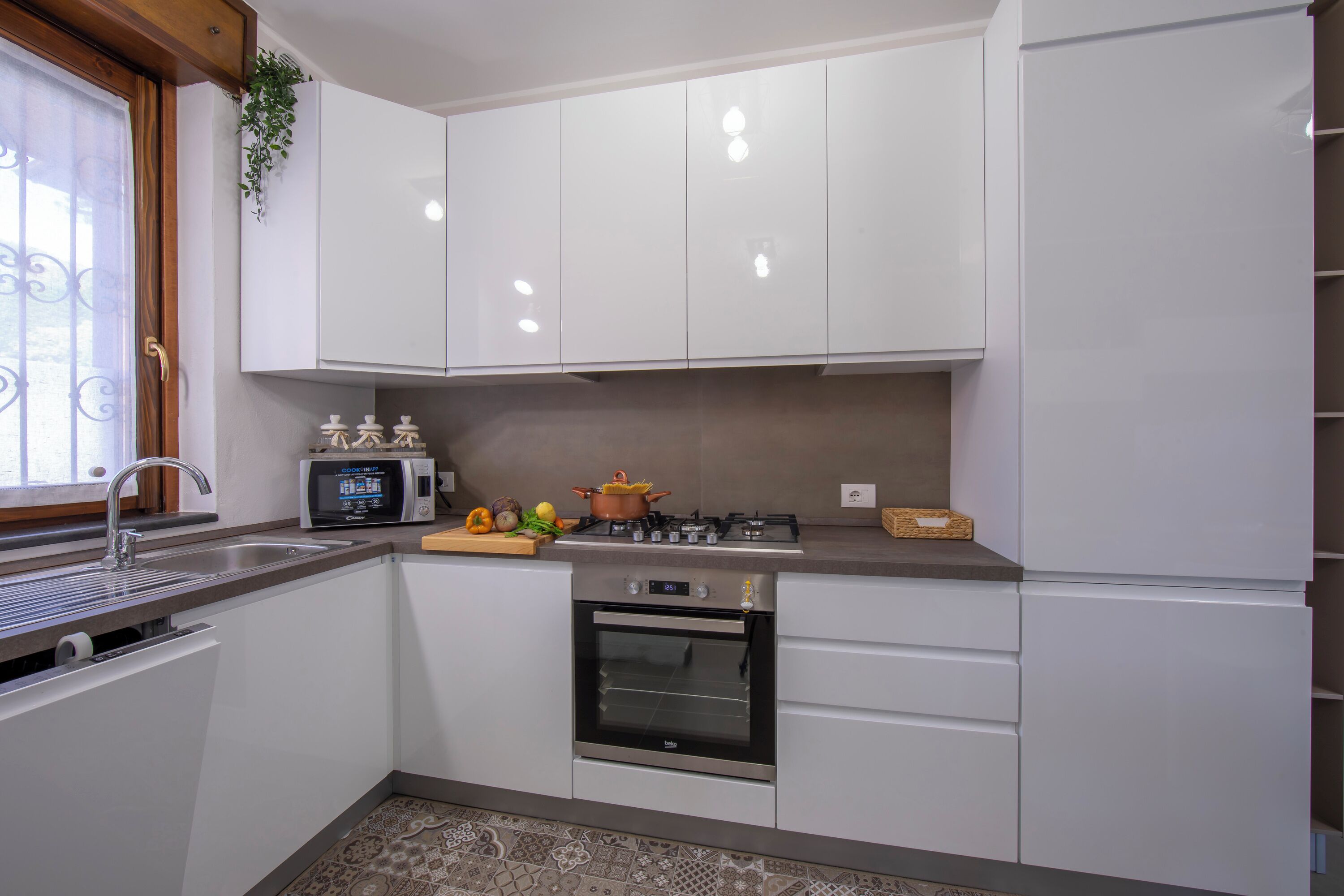 Una cocina moderna con armarios blancos, microondas, estufa y horno.