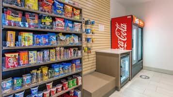 A snack and beverage section with various packaged snacks, a refrigerated display, and a Coca-Cola refrigerator.