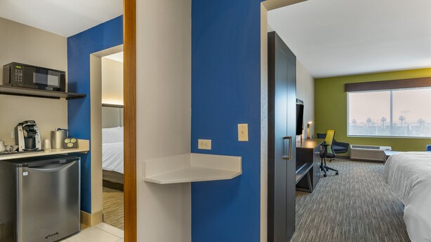 A hotel room with a kitchenette, a bed, a desk, and a view of the city. - Holiday Inn Express & Suites Phoenix Dwtn - State Capitol by IHG (Phoenix)