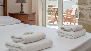 Une chambre d’hôtel avec un lit, une table de chevet avec une lampe et une vue sur la terrasse extérieure.