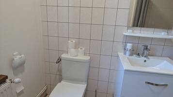 Une salle de bain avec des toilettes, un lavabo et un miroir.