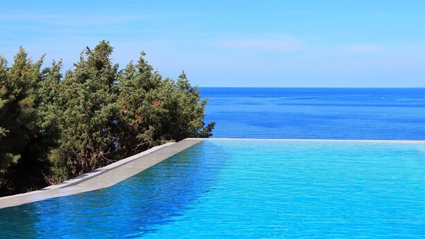A clear blue pool with a view of the ocean and dense greenery. - Exclusive clifftop villa in the heart of Gallura with infinity pool (Trinità d'Agultu e Vignola)