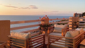 A wooden deck with outdoor seating and a view of the ocean. - Exclusive clifftop villa in the heart of Gallura with infinity pool (Trinità d'Agultu e Vignola)
