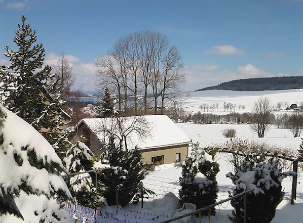 Escape to a serene winter wonderland with a picturesque barn nestled among snow-covered trees.