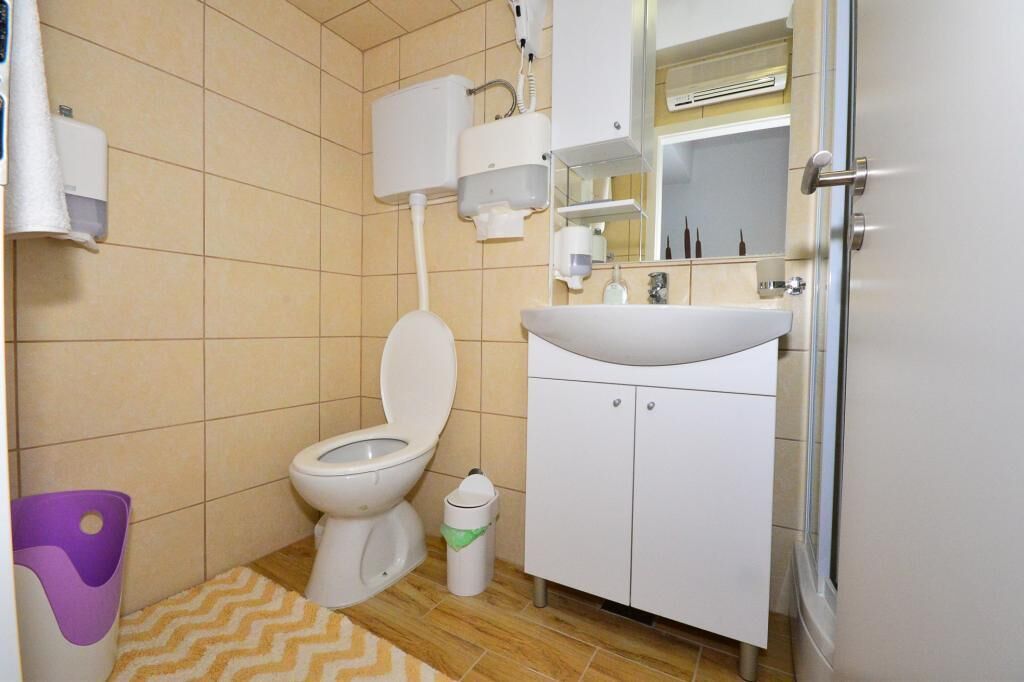 Ein Badezimmer mit Toilette, Waschbecken und Handtrockner.