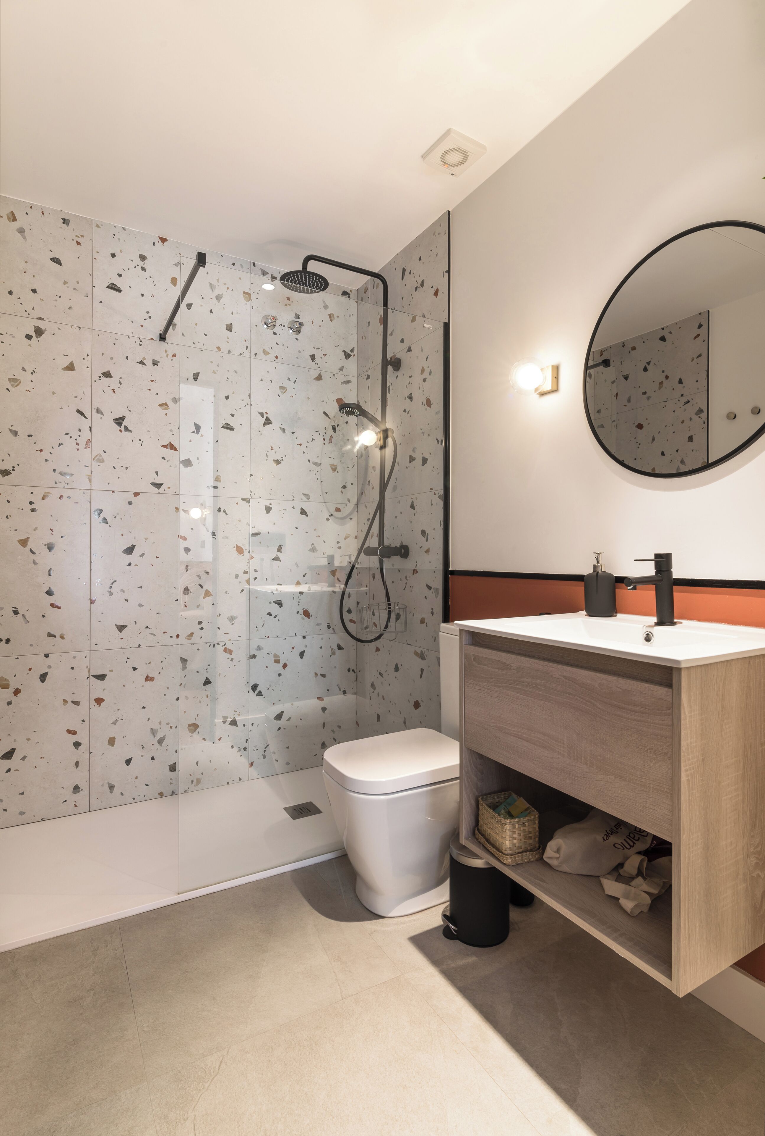 A modern bathroom with a shower, toilet, and vanity.