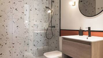 A modern bathroom with a shower, toilet, and vanity.